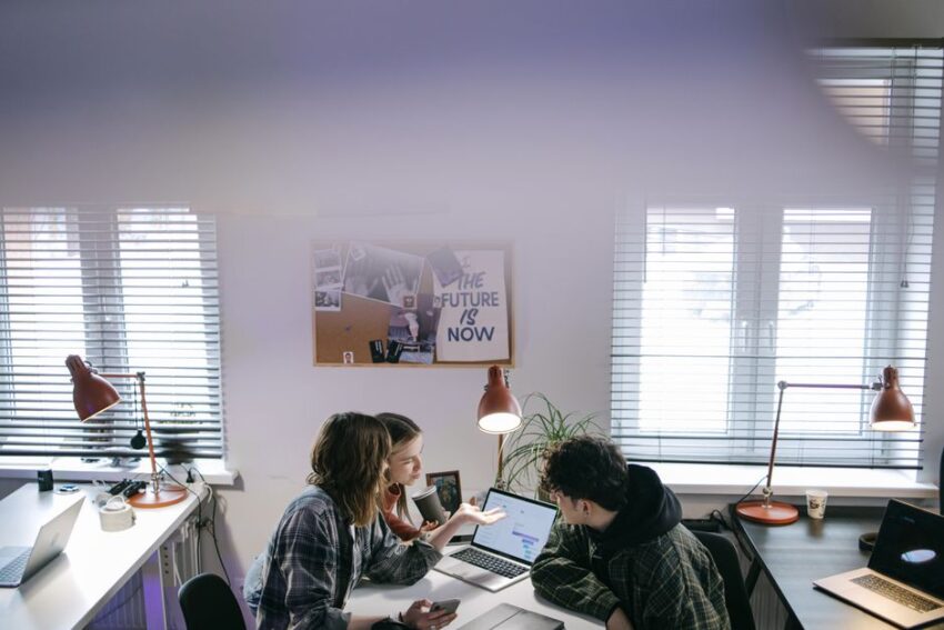 Een team van blije medewerkers die samenwerken in een moderne kantooromgeving, symbool voor sterk employer branding.